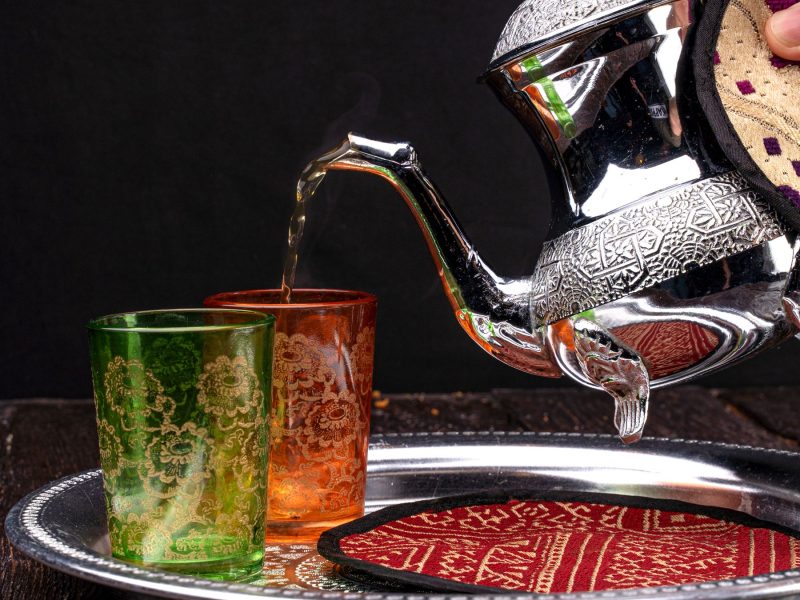 Mint tea poured from a silver teapot into Moroccan glasses